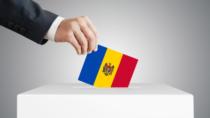 Man putting a ballot into a voting box.